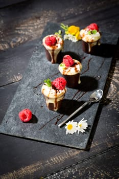 Chocolate cups with vanilla pudding,cream and raspberries