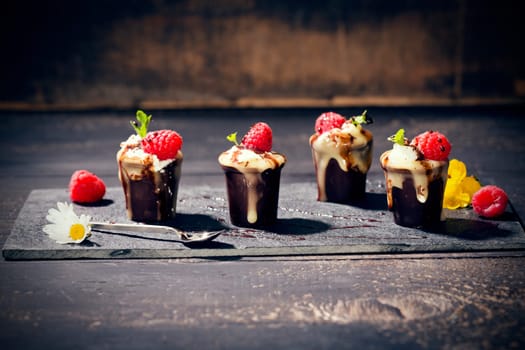 Chocolate cups with vanilla pudding,cream and raspberries