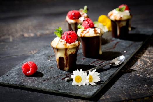 Chocolate cups with vanilla pudding,cream and raspberries