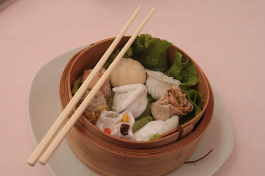 wontons in wooden bowl with sticks