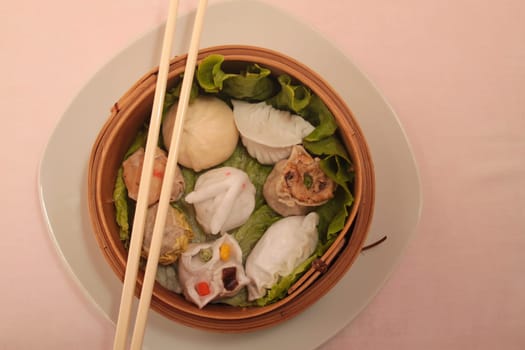 wontons in wooden bowl with sticks