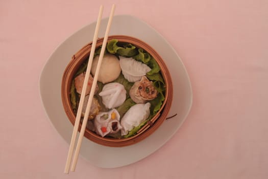 wontons in wooden bowl with sticks