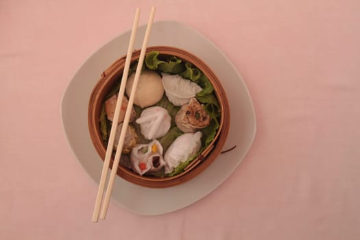 wontons in wooden bowl with sticks