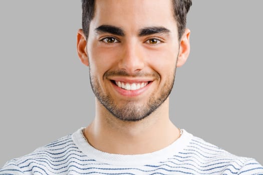 Portrait of happy handsome young man looking through his hands