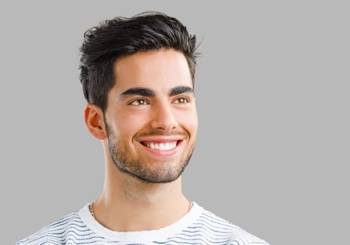 Portrait of happy handsome young man looking through his hands