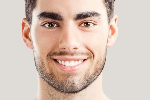 Portrait of happy handsome young man looking through his hands