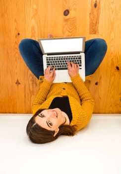 Beautiful woman sitting on the floor working with a tablet