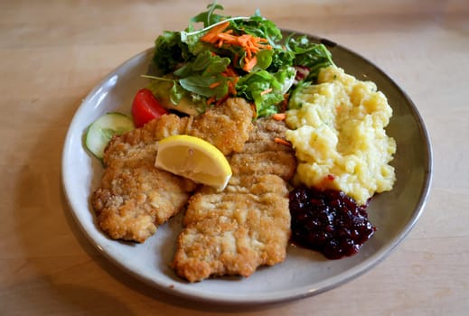 A veal schnitzel, a Wiener schnitzel with potato stamp, mashed potatoes on a plate.