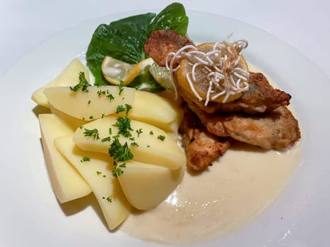 A deliciously prepared and served fillet of pike-perch on a white plate.