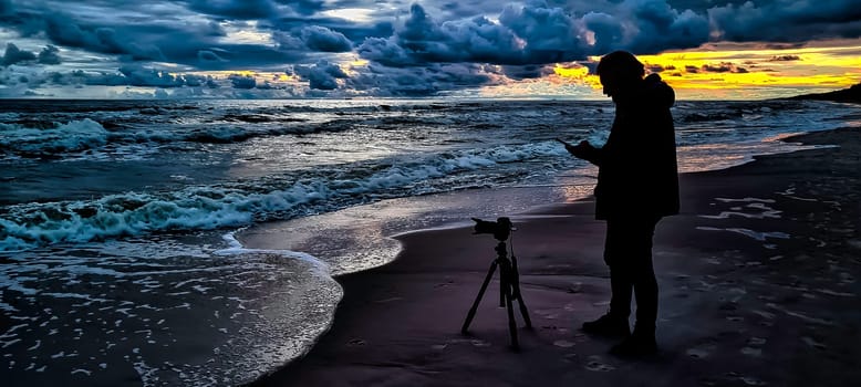 Sunset over Baltic Sea with photographer and oil platform in background - Lubiatowo, Pomerania, Poland