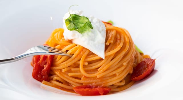 Italian pasta - spaghetti with burrata cheese closeup, mediterranean diet