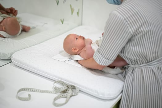 Baby lying on his back being messured during a standard medical checkup