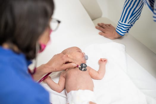 Baby lying on his back as his doctor examines him during a standard medical checkup.