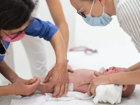 Baby beeing vaccinated by pediatrician in presence of his mother. Preventive vaccination against Diphtheria, whooping cough, tetanus, hepatitis, haemophilus influenzae, pneumococcus, poliomyelitis.