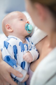 Young mother is holding her little baby