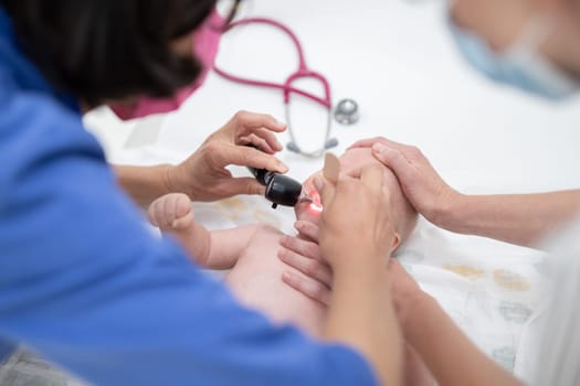 Baby lying on his back as his doctor examines him during a standard medical checkup.