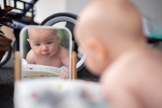 Beautiful shot of a cute baby boy looking at his reflection in the mirror