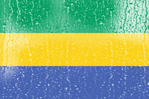 3D Flag of Gabon on a glass with water drop background.