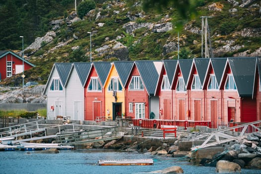 Alnes, Godoya, Norway. Red And Yellow Colorful Wooden Docks In Summer Day. Godoy Island Near Alesund Town.