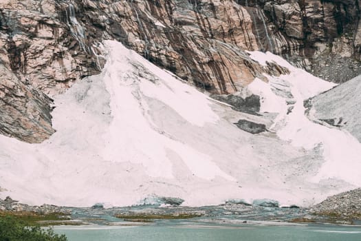 Jostedalsbreen National Park, Norway. Close Up View Of Melting Ice And Snow, Small Waterfalls On Boyabreen Glacier In Summer Sunny Day. Famous Norwegian Landmark And Popular Destination. Close Up.
