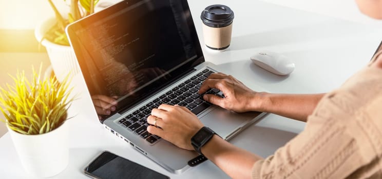 Programmer woman writing program HTML code sitting at workplace in office, IT software developer hands typing data coding programming with laptop computer, IT start up concept, Web application design