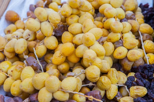 Bunches of round yellow dates, barhi variety. Displayed at street market stall