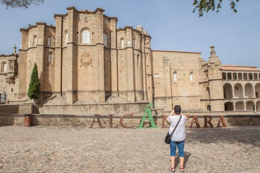 Tourist taking pictures at Convent of San Benito, parent headquarters of the order of Alcantara, Caceres, Extremadura, Spain