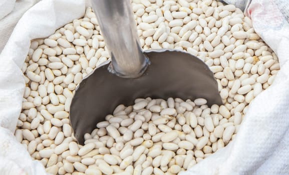 White beans in rolled up sack. Displayed at street market stall