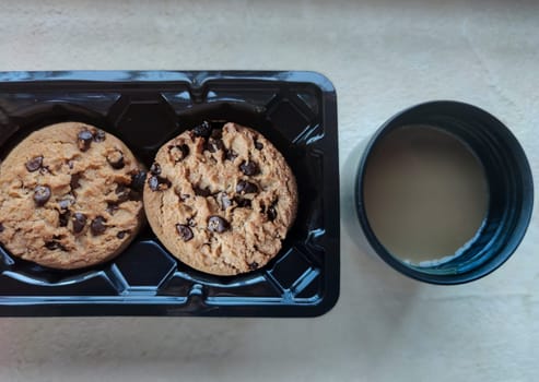 Chocolate chip cookies in the package and vacuum flask coffee cup. Coffee at work concept
