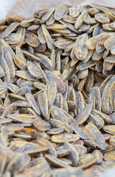 Whole roasted sunflower seeds on rolled up sack. Displayed at street market stall