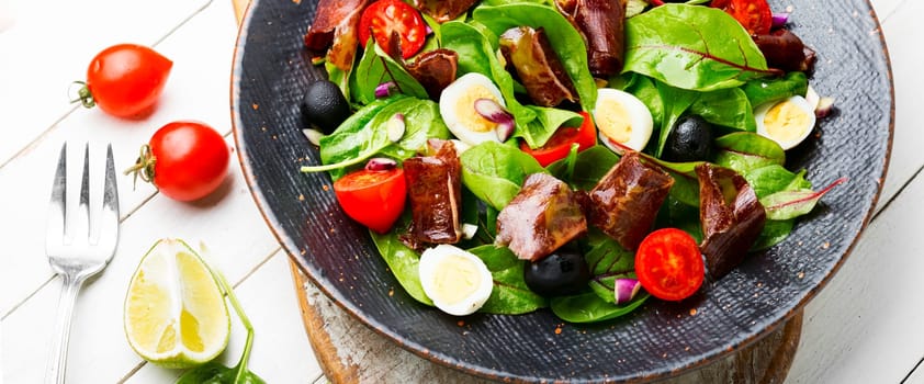 Fresh dietary salad with greens, tomato, egg, lime slices of meat.Top view