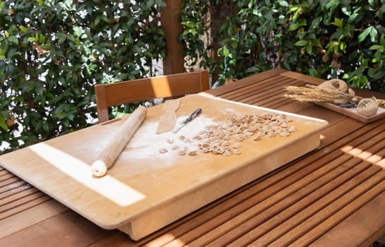 Preparing south italian pasta orecchiette outdoor in the house yard close up. Traditional fresh homemade pasta of apulia region. Mediterranean diet ingredient. Local cousine