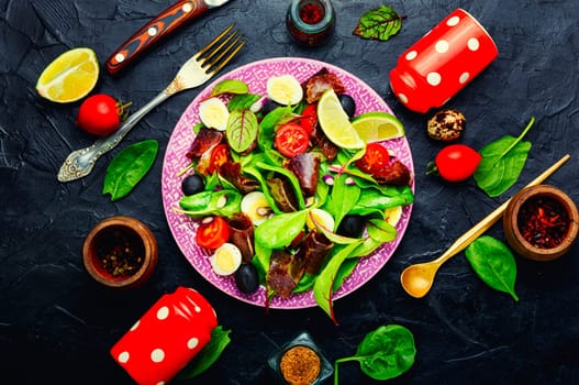 Fresh dietary salad with greens, tomato, egg, lime slices of meat.Top view