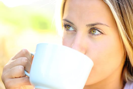 Woman with beauty eyes drinking coffee outdoors
