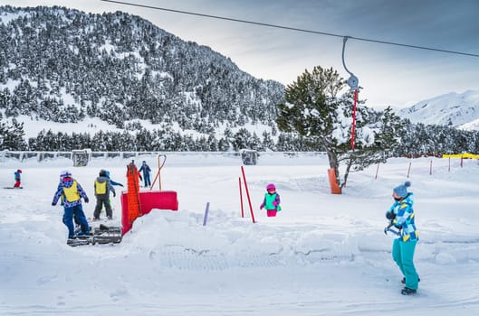 Ski trainers teaching group of young kids how to ski in ski school Mother watching her daughter on ski Winter holidays in Andorra Pyrenees Mountains