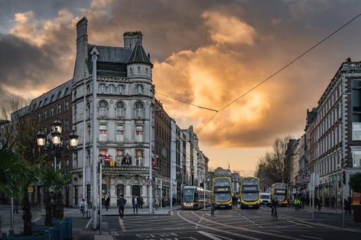 Dublin, November 2019 Early morning, sunrise, on busy OConnell Bridge with a view on National Wax Museum. Luas and bus stop or hub on Westmoreland St