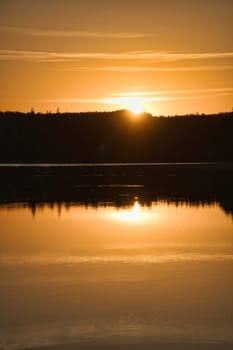 Sunset with reflection on a Swedish lake in Smalland. Romantic evening mood. Landscape shot from Scandinavia in nature