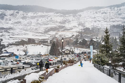 El Tarter, Andorra, Jan 2020 People, families with ski and snowboard equipment walking on main parking with ski lifts, Pyrenees Mountains