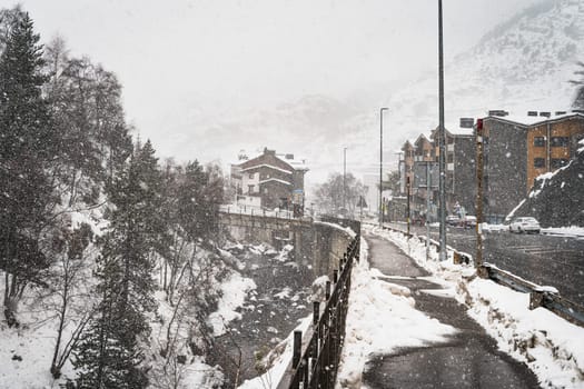 Heavy snow fall in El Tarter city. Street and sidewalk leading to the town and ski resorts in Pyrenees Mountains, Grandvalira, Andorra