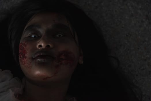 Horror evil woman ghost creepy lying dead in a dark room at house. Female zombie in blood devil is scary she haunted at the abandoned building, Happy Halloween festival day concept