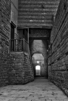 Black and white shot of old abandoned stone bricks passage surrounding Sultan Qalawun Complex located in Al Moez Street, Cairo, Egypt