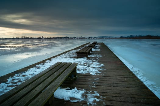 View from the pier to the frozen lake in the winter evening, Zoltance, Lubelskie, Poland