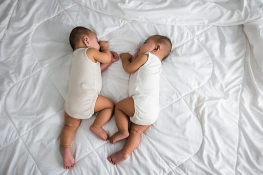 Happy childhood, Sleeping newborn identical boy twins on the bed on bedroom, Asian two adorable twin babies boy, family people infant