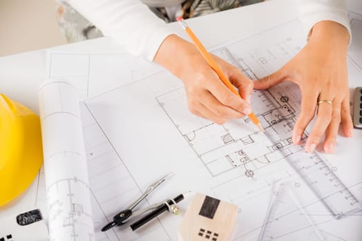 Architectural project workspace. Top view of architect drawing with ruler on house plan blueprint paper for repair tools on table desk at architecture office, architect sketching construction project