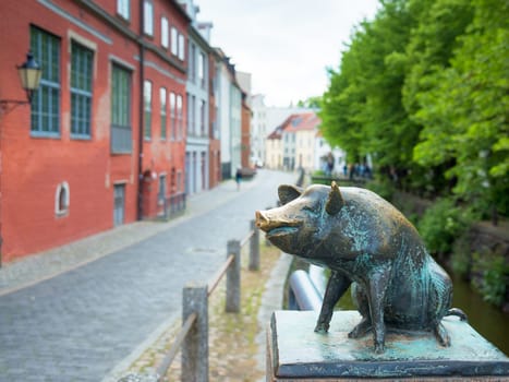 Pig as a bronze statue on the canal bridge in the city of Wismar.