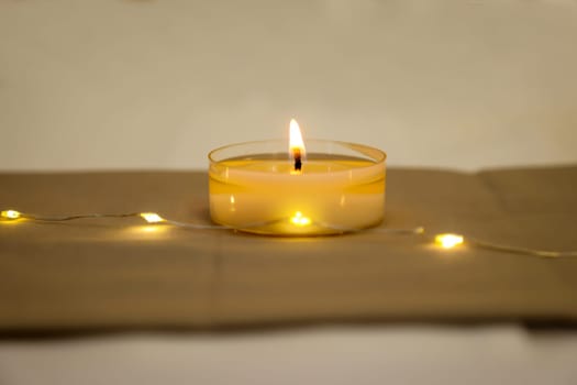 A burning tea light as a table decoration on a festively set table.