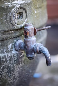 A drain han is attached to an old beer barrel.