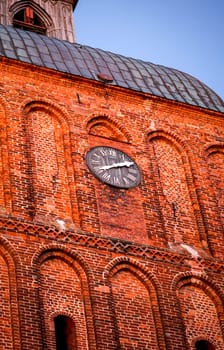 A detailed view of a church tower built of red bricks.