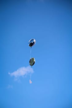 Balloons with greetings and messages rise into the sky at a wedding.