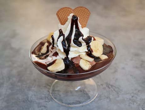 A banana sundae with whipped cream and chocolate sauce.
